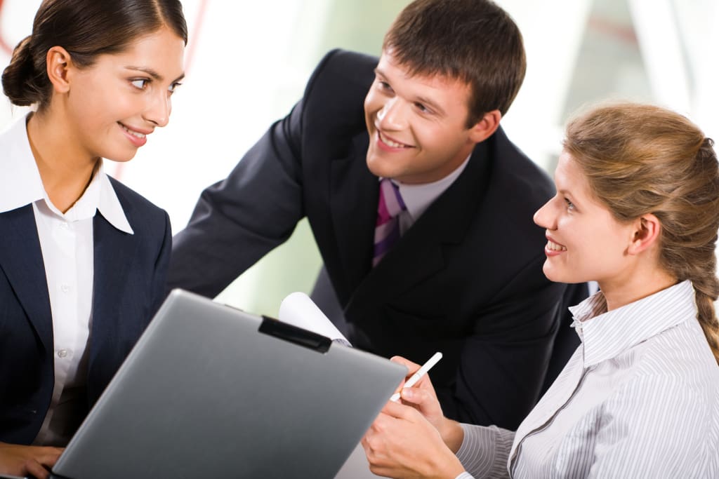 Portrait of three white collar worker interacting at business meeting.